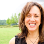 A picture of Cintia Aguilar, a woman with shoulder length brown hair, smiling. 